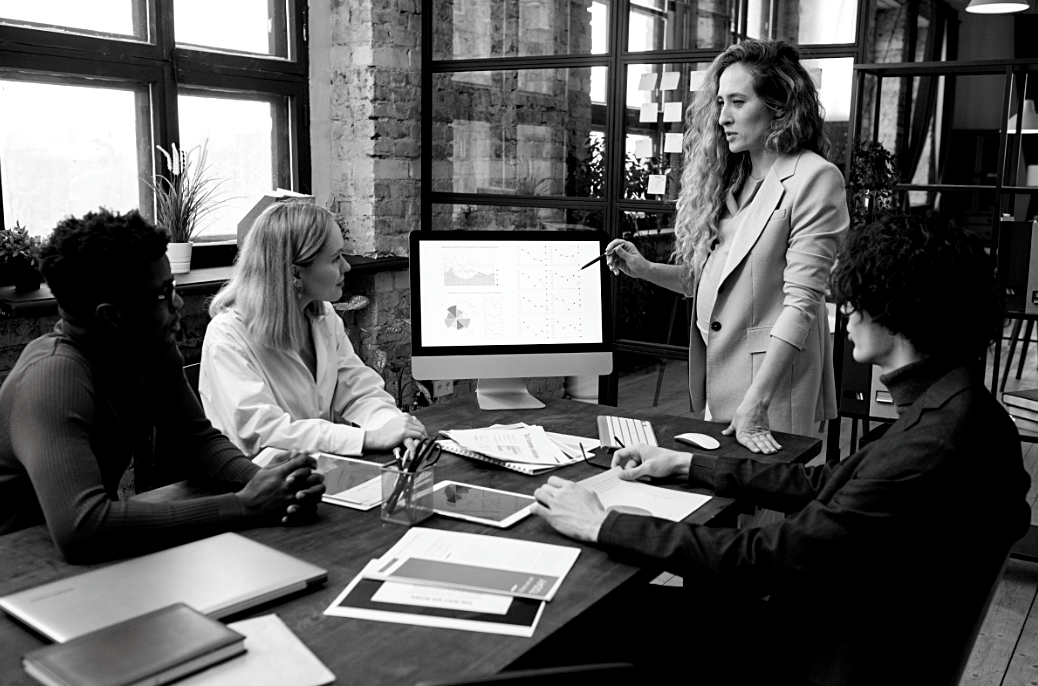 Photo en noir & blanc, réunion , femme montrant un graphique sur ordinateur